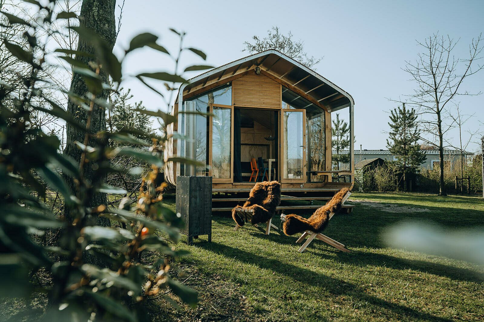 Wikkelhouse Bear bij De Klepperstee met glazen voorgevel en twee stoelen in de tuin