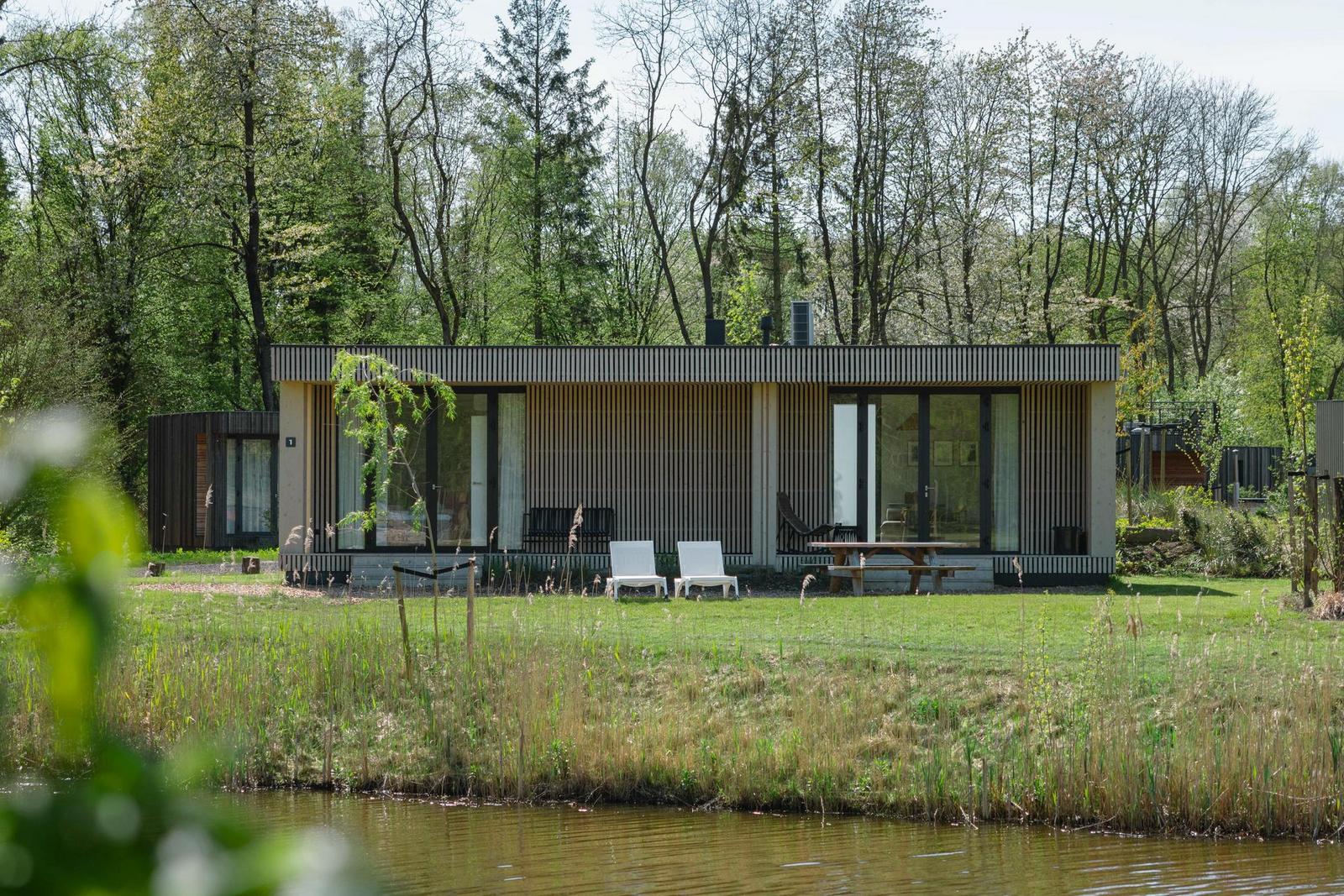 Houten Lodge bij Resort de Parel met veranda en grasveld aan het water